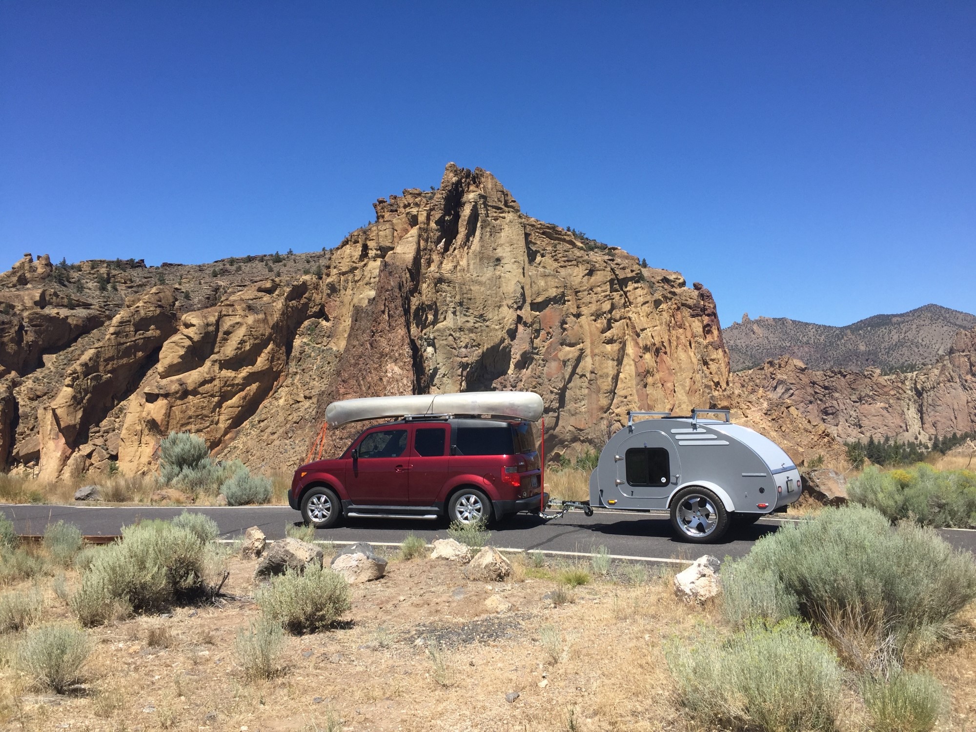 small teardrop trailer being towed by crossover